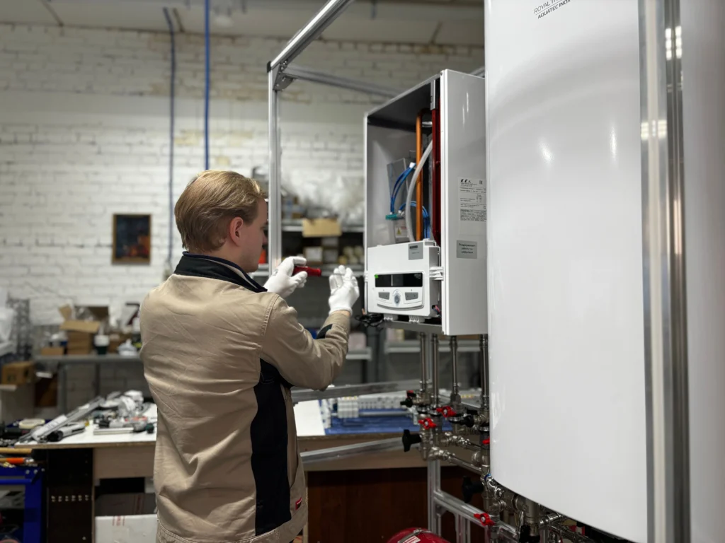 Un technicien inspecte et répare un système de chauffage dans un atelier industriel.